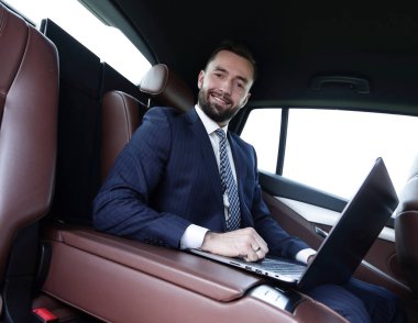 başarılı adam arabanın içinde otururken dizüstü bilgisayar ile çalışma