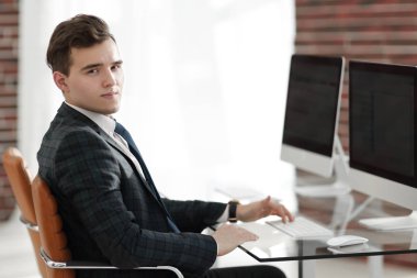 bir masanın arkasında ofiste çalışan