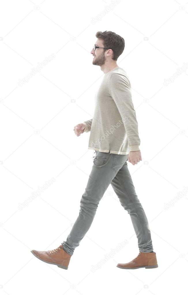 Side view.Young smiling man walking forward