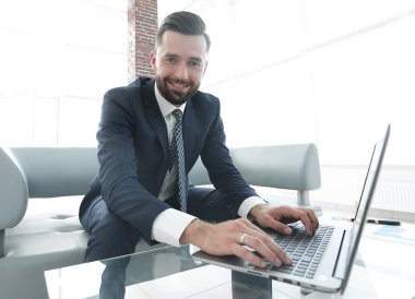 Modern ofis dizüstü bilgisayarda çalışan başarılı erkeğin