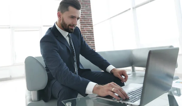 Biznesmen pracy na laptopie siedząc w holu urzędu — Zdjęcie stockowe