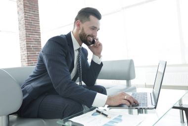 Smartphone üzerinde konuşmak ve metin dizüstü bilgisayarda yazarak işadamı