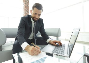Dizüstü bilgisayarda çalışan ve Notlar not defterinde yapma şık adam