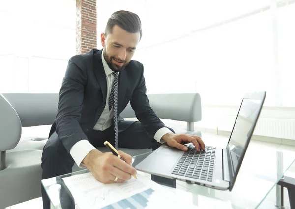 Hombre con estilo que trabaja en el ordenador portátil y toma notas en el cuaderno —  Fotos de Stock