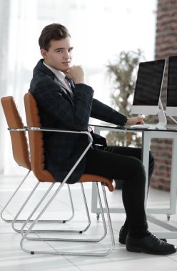 bir masanın arkasında ofiste çalışan