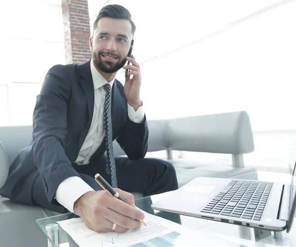 Empresário falando no smartphone sobre documentos financeiros — Fotografia de Stock