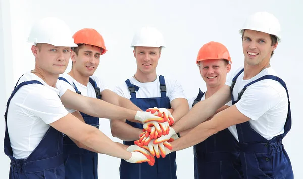 Equipe de construtores de pé com as mãos apertadas juntas — Fotografia de Stock