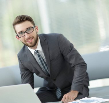 Masasında oturan modern bir işadamı portresi.