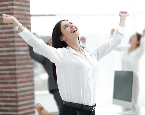 Gelukkig jonge zakenvrouw op een achtergrond wazig office. — Stockfoto