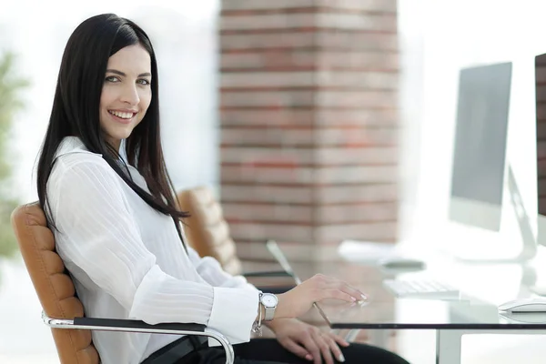 Giovane donna d'affari di successo seduta sul posto di lavoro — Foto Stock