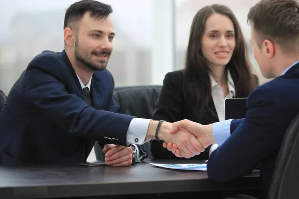 Handslag finansiella partner sitter vid bordet — Stockfoto