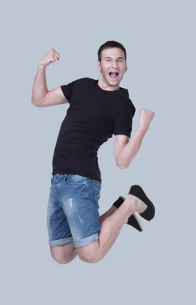 Смешной веселый счастливый человек, прыгающий в воздух на сером фоне — стоковое фото