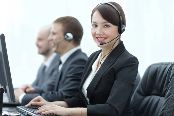 Hermosa gente de negocios en auriculares están utilizando computadoras — Foto de Stock