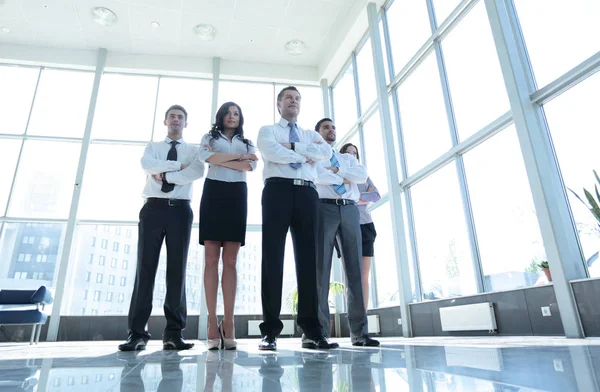 Sorrindo e confiante equipe de negócios em pé na frente de um brilhante — Fotografia de Stock