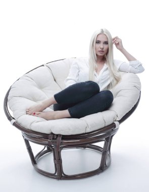 Kanepede rahat bir şekilde oturan güzel bir genç kadın.