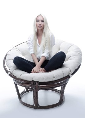 büyük bir rahat tekli koltukta oturan güzel genç kadın.