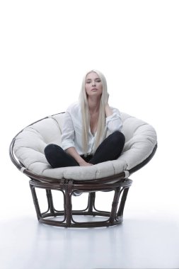 Kanepede rahat bir şekilde oturan güzel bir genç kadın.