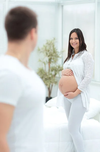 Zwangere vrouw die lacht met haar man thuis — Stockfoto