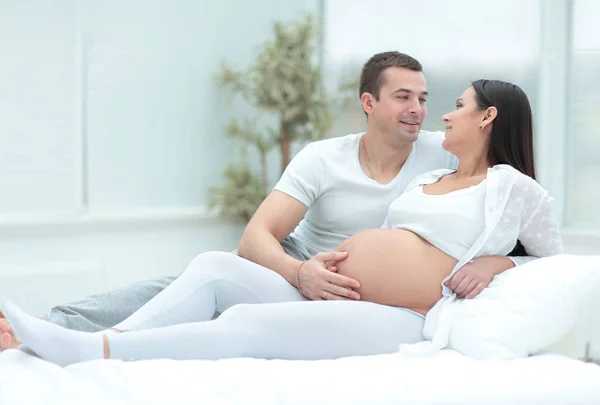 Femme enceinte avec son mari relaxant à la maison — Photo