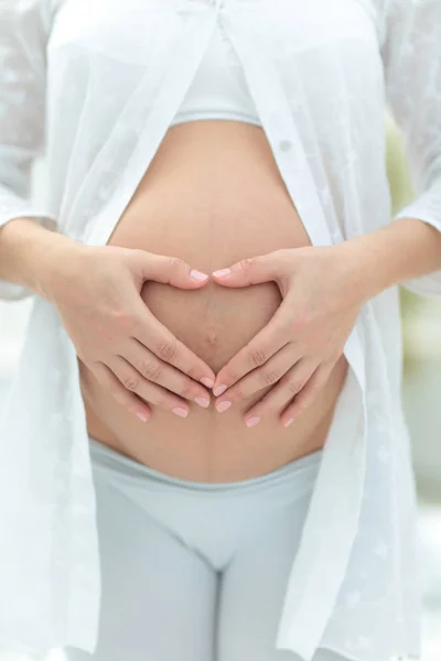 Abgeschnittenes Bild einer schwangeren Frau, die den Bauch umarmt — Stockfoto