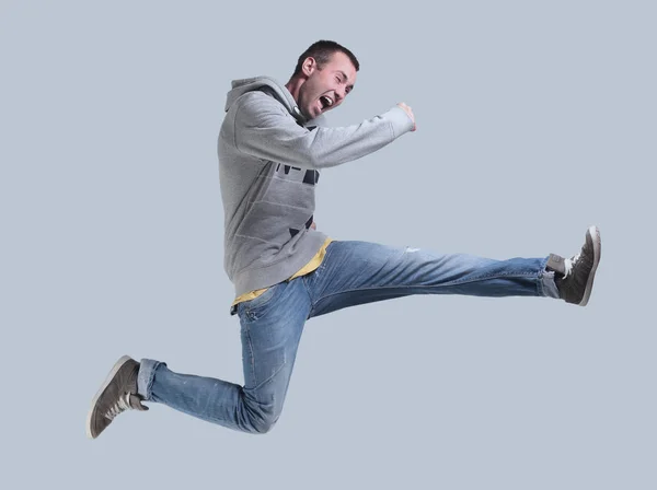 Смешной веселый счастливый человек, прыгающий в воздух на сером фоне — стоковое фото