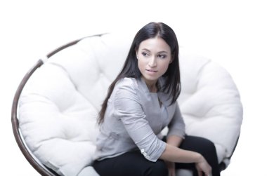 Genç kadın bir yuvarlak rahat yumuşak büyük sandalyede oturuyor.