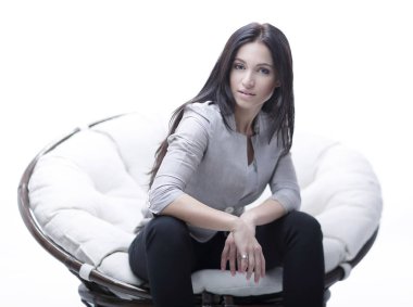 Genç kadın bir yuvarlak rahat yumuşak büyük sandalyede oturuyor.