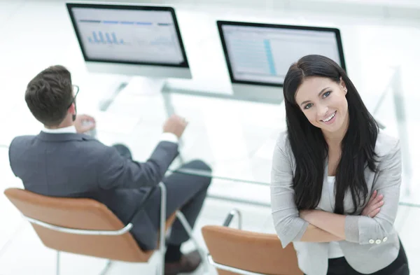 Mujer de negocios exitosa de pie cerca del lugar de trabajo moderno — Foto de Stock