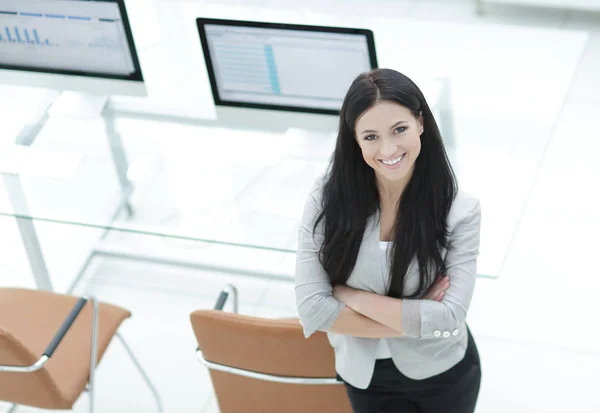 Молода бізнес-леді стоїть біля сучасного робочого місця . — стокове фото