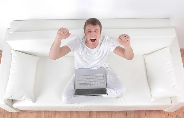 Successful man with arms up working on laptop at home — Stock Photo, Image