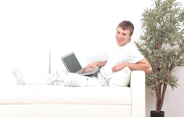 Bonito jovem relaxante em casa sentado na sala de estar — Fotografia de Stock