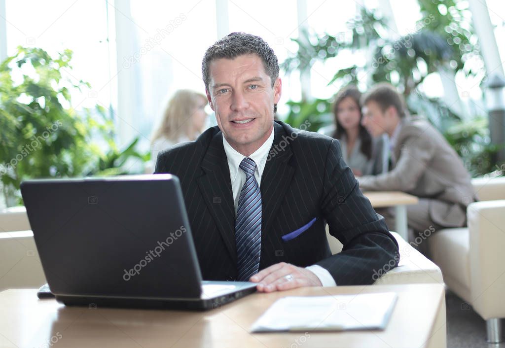 Happy middle age businessman looking at camera and smiling.