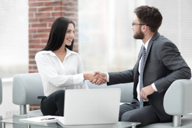 Yöneticisi ve müşteri ofis lobisinde otururken el sıkışma.