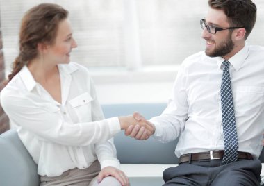 Ofis lobisinde yönetici ve müşterinin el sıkışması.