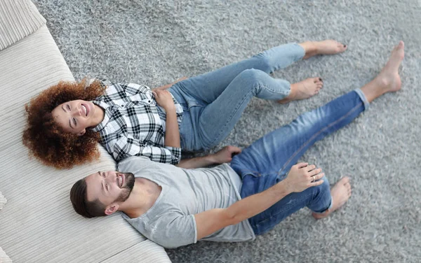 Above newlyweds lying on the carpet in a new apartment — Stock Photo, Image