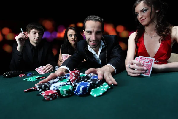 Poker players sitting around a table at a casino Stock Photo