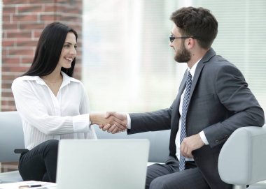 Yöneticisi ve müşteri ofis lobisinde otururken el sıkışma.