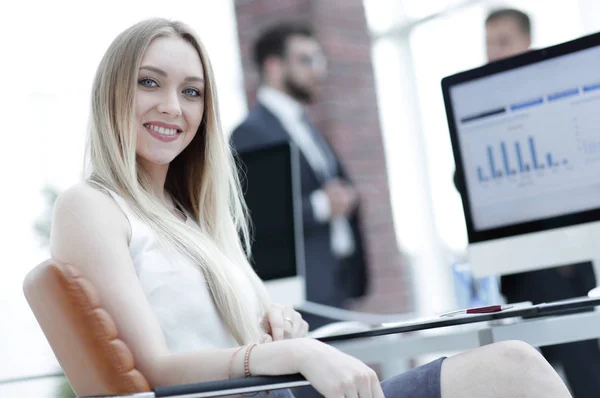 Junge Geschäftsfrau sitzt an einem Schreibtisch im Büro . — Stockfoto