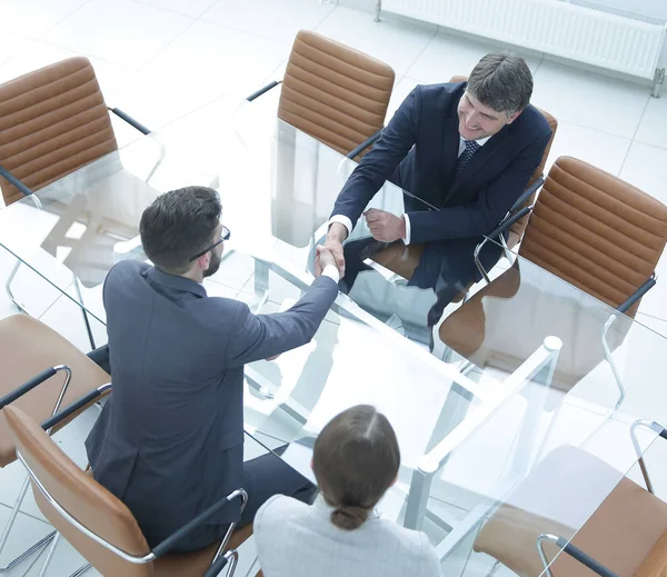 Handslag över bordet med finansiella partner — Stockfoto