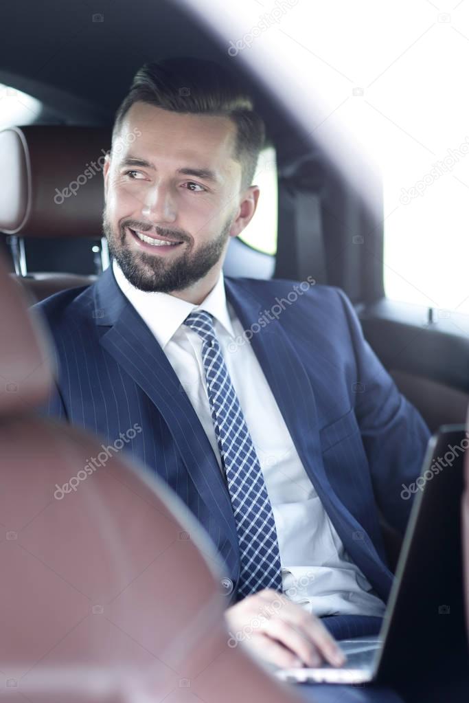 Portrait of a business man in the back seat of a car