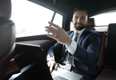 parmağını ileriye dönük ve arabanın arka koltukta oturan işadamı