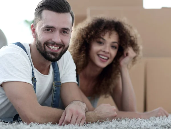 Pareja feliz en el fondo de cajas de cartón — Foto de Stock