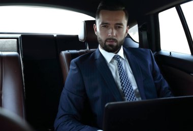 işadamı ile rahat bir arabada oturan laptop