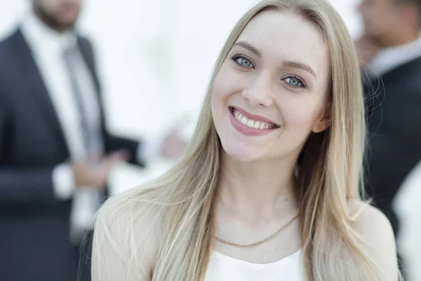 Närbild porträtt av en ung kvinna mot bakgrund av kollegor — Stockfoto
