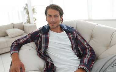 başarılı adam modern oturma odasında dinleniyor.