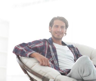 gülümseyen bir adam büyük bir koltukta otururken köpeğini okşayarak Close-Up.