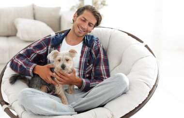 yakışıklı olan büyük bir koltukta oturan bir köpekle.