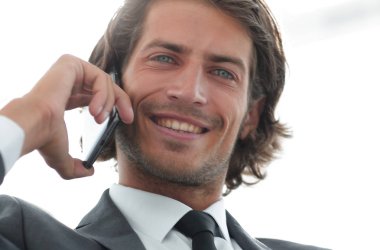 iş adamı rahat bir sandalyede otururken Smartphone'da konuşuyor.