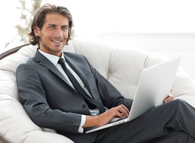 işadamı bir şık rahat chai oturan bir dizüstü bilgisayar ile