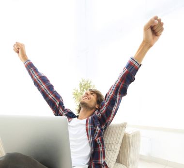 çok mutlu genç adam evde laptop ile çalışma.